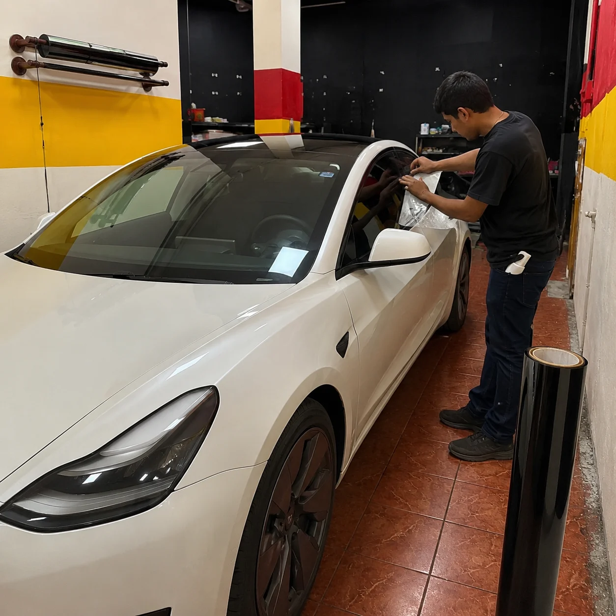 Window tint being installed on a white Tesla in our Sharjah workshop